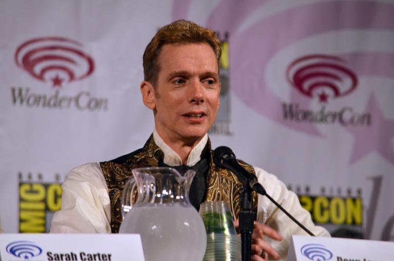 A man sits at a microphone.