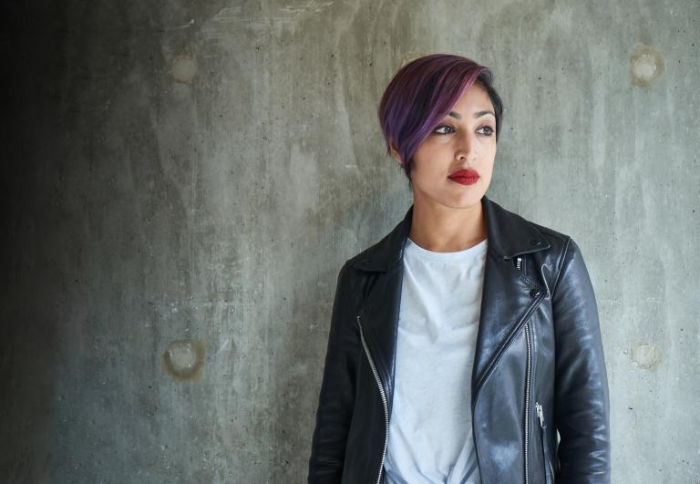 A woman in a black leather jacket. Partially obscured.