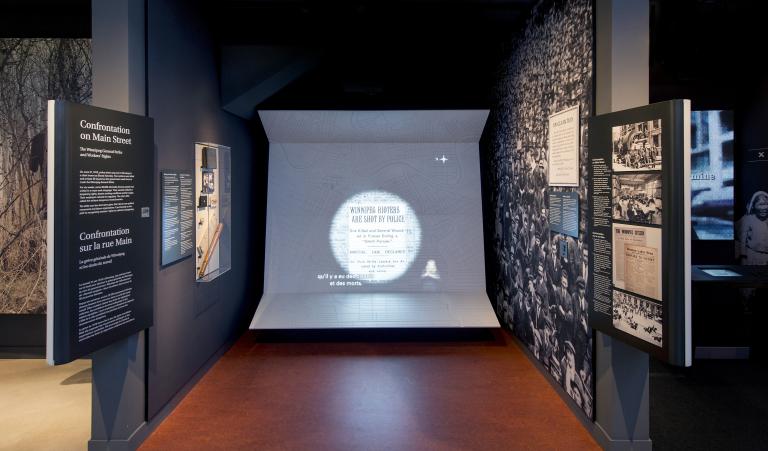 A Museum display including photos, text and large video display that has captions and sign language interpretation.