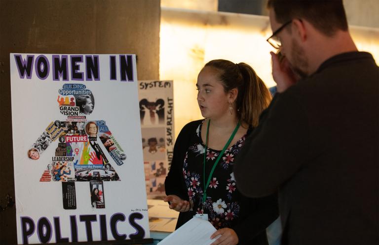 Two people looking at a poster. Partially obscured.