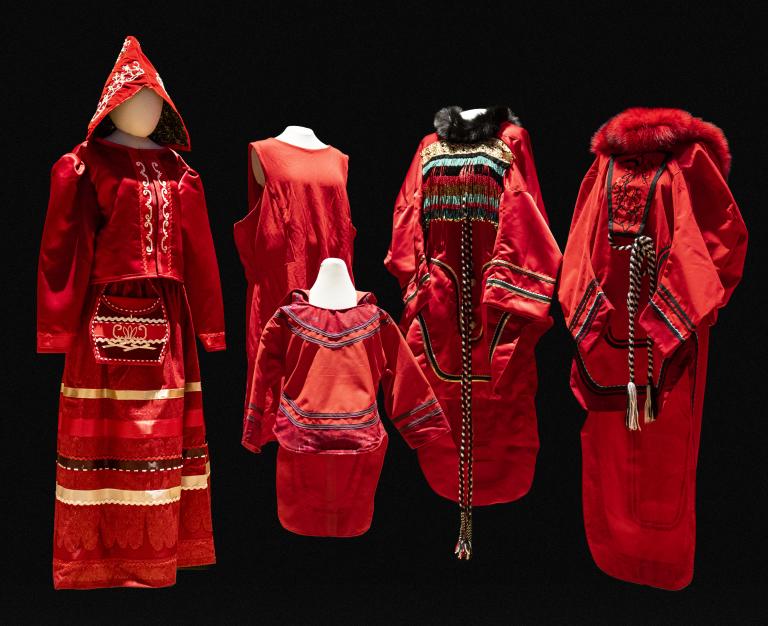 5 red dresses of different sizes and designs are displayed on mannequins. Partially obscured.