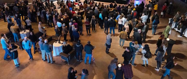A crowded hall of people. Partially obscured.