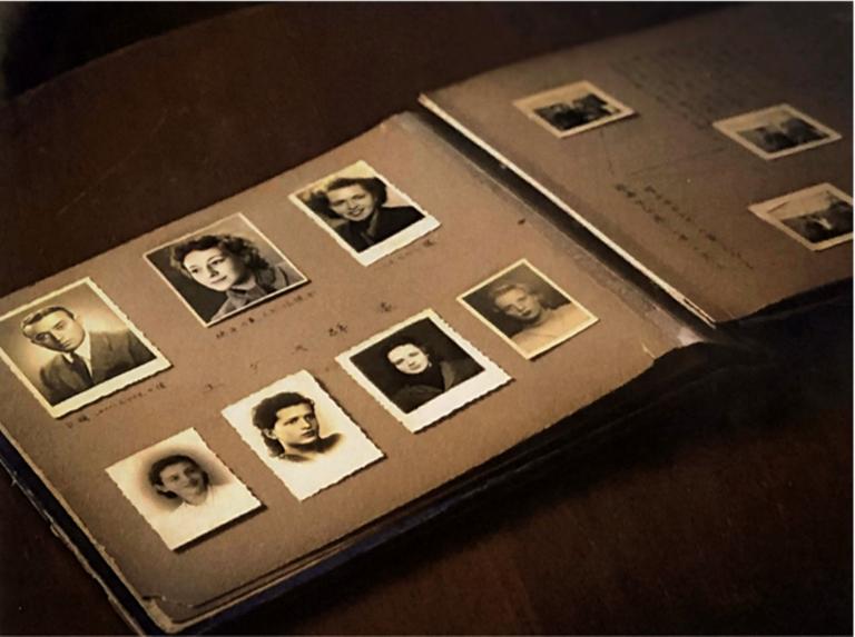 An open photo album contains black-and-white headshots of seven individuals and other annotated photos Partially obscured.