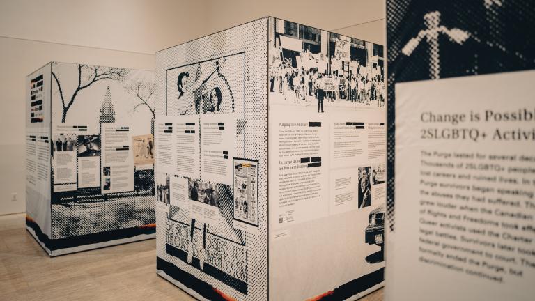 A pop-up exhibition showing three separate black and white cube-shaped panels. The closest one displays "Change is possible." Partially obscured.