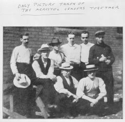 A group of men standing and sitting.